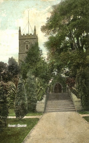 Broad steps leading up to the south entrance of a small church. The grounds contain a wide variety of trees.