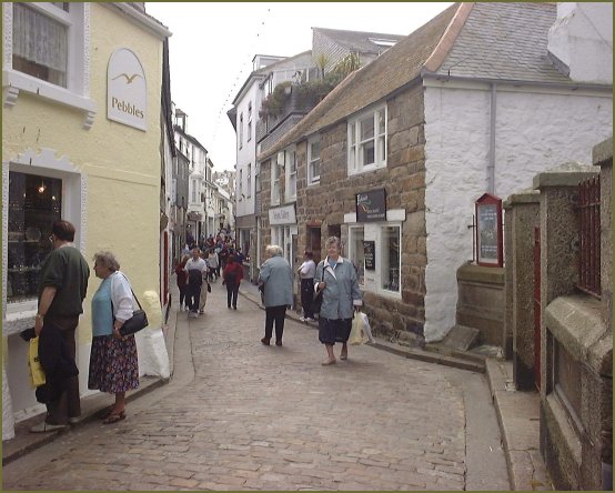 A cobbled lane with shops, free of traffic, now devoted to holiday browsing