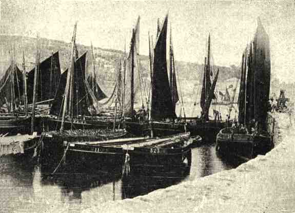 A small harbour with a dozen gaff rigged fishing boats